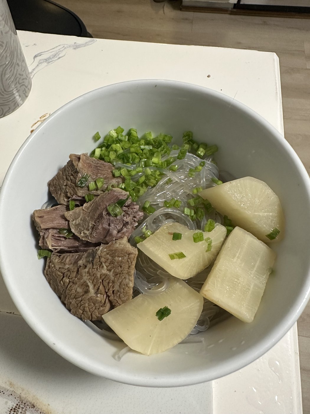 Beef, radish and glass noodles in a white bowl
